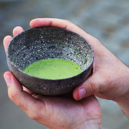 A textile design chawan matcha bowl with bright green matcha tea