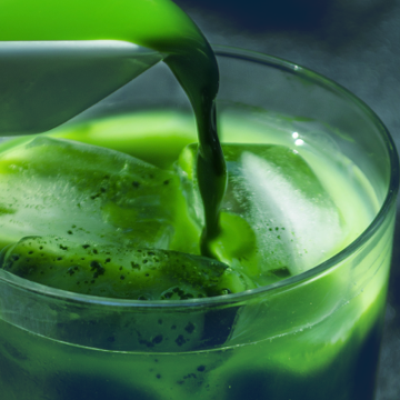 Freshly whisked matcha being poured over ice in a glass, creating a vibrant and refreshing Japanese iced matcha drink.