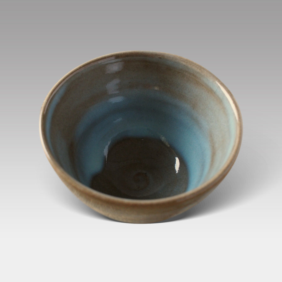 Top view of Mashiko-style matcha bowl showing smooth spiral base and glossy blue-green glazed interior, handcrafted in Japan.