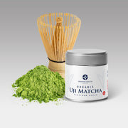 Organic Uji Matcha Platinum Blend can beside fresh matcha powder and bamboo whisk, ideal for tea ceremony or matcha latte