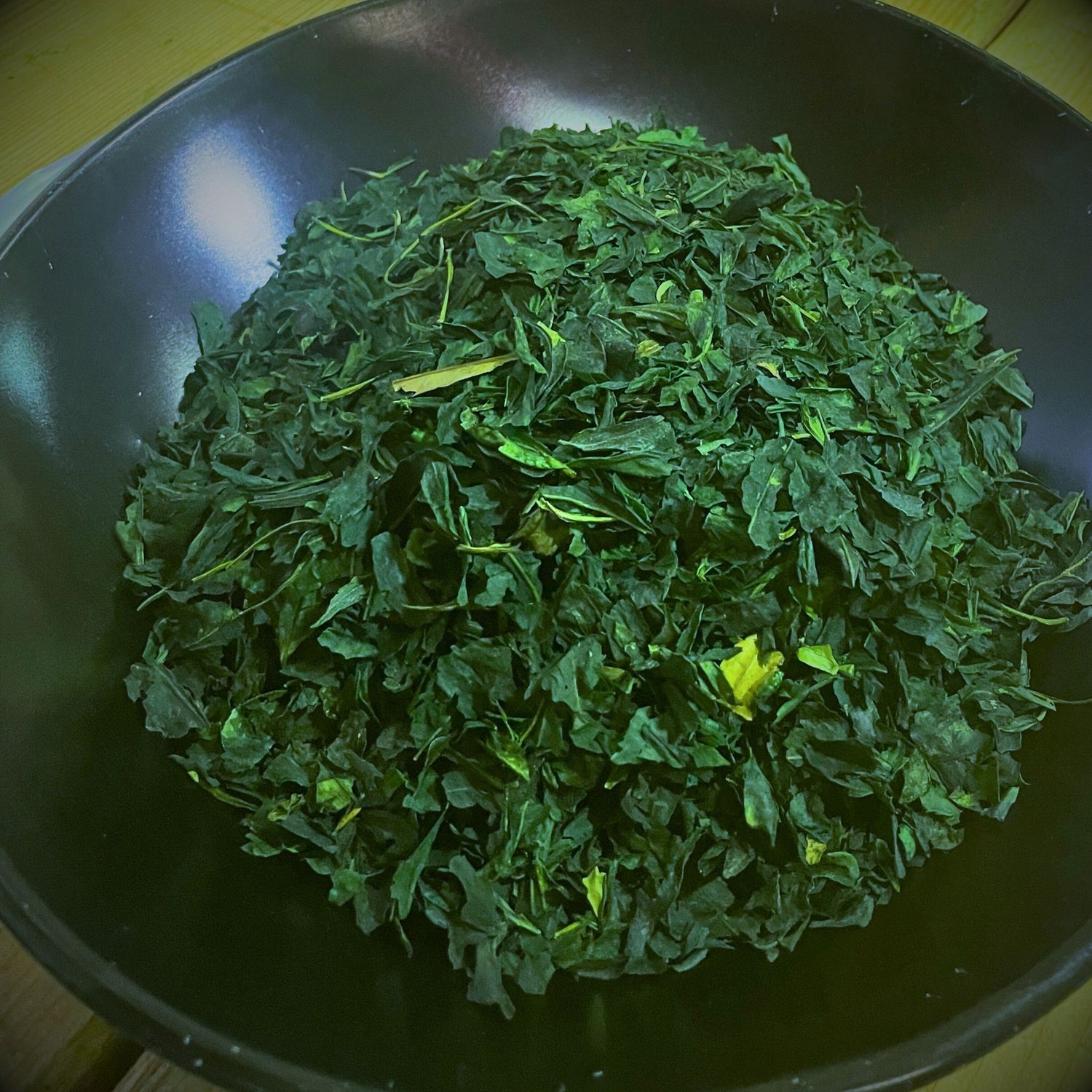 Bowl of shade-grown tencha leaves, the raw material for premium Uji matcha, harvested in Kyoto before stone milling.