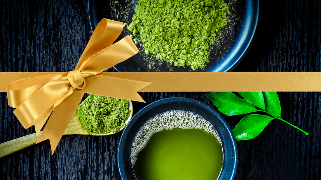 A bowl of matcha and matcha powder with an orange bow to symbolize it as a gift