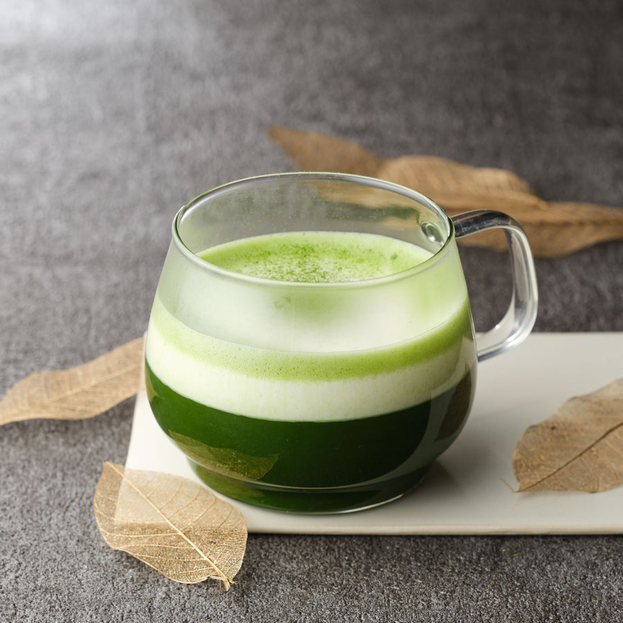 Layered matcha latte made with Uji Matcha Asahi in a clear glass mug, showing deep green matcha beneath white milk foam