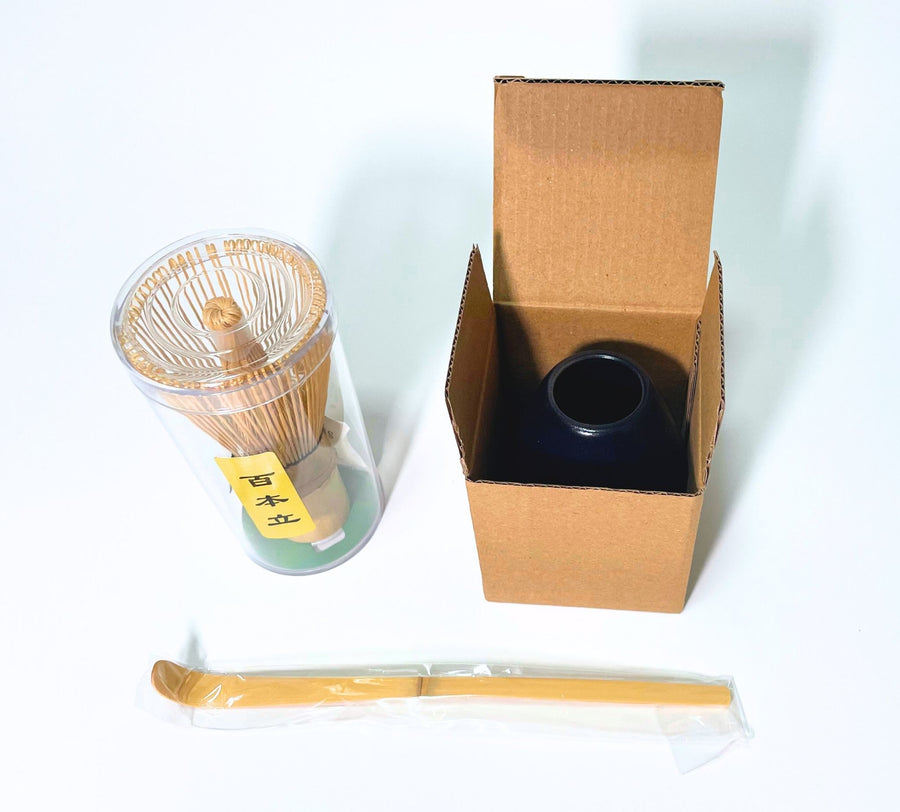 Matcha whisk set packaging with bamboo whisk in plastic case, scoop in sleeve, and whisk holder in open cardboard box
