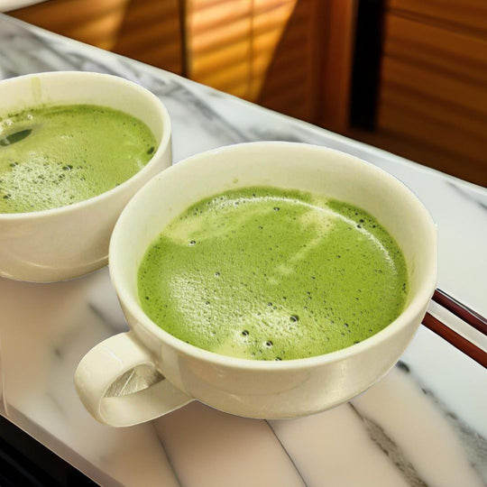 Matcha lattes in mugs on a countertop