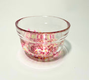 Japanese glass matcha bowl with pink plum blossom pattern on white background