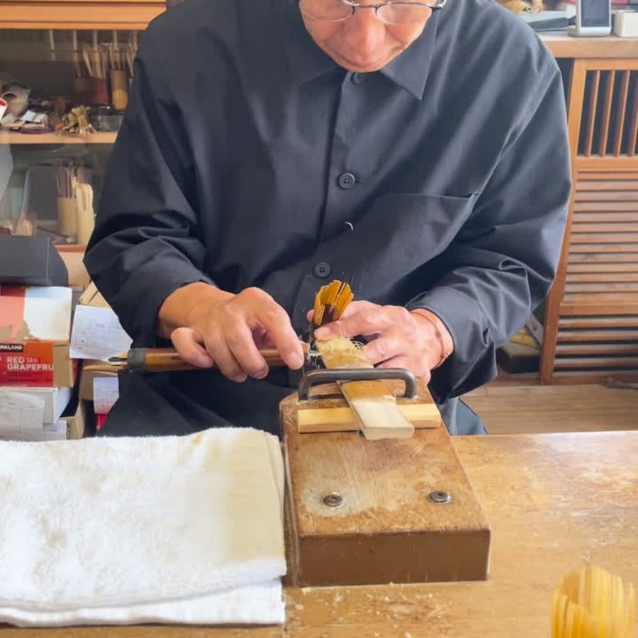 A craftsman at the Suikaen workshop carving the tines of a bamboo chasen by hand.