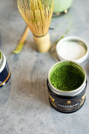 View of an opened can of organic matcha powder focusing on the vibrant green color 