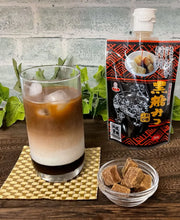 Iced coffee latte sweetened with Okinawa Brown Sugar Syrup (Kokuto Mitsu), served alongside authentic Japanese black sugar syrup and traditional kokuto sugar cubes.