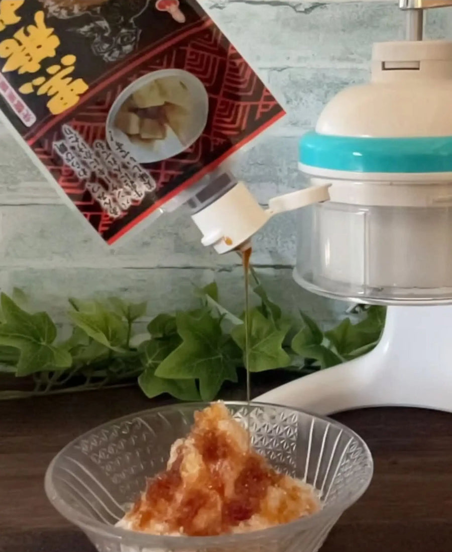 Okinawa Brown Sugar Syrup (Kokuto Mitsu) being poured over Japanese kakigori shaved ice, showcasing its rich texture and authentic Okinawan black sugar flavour.