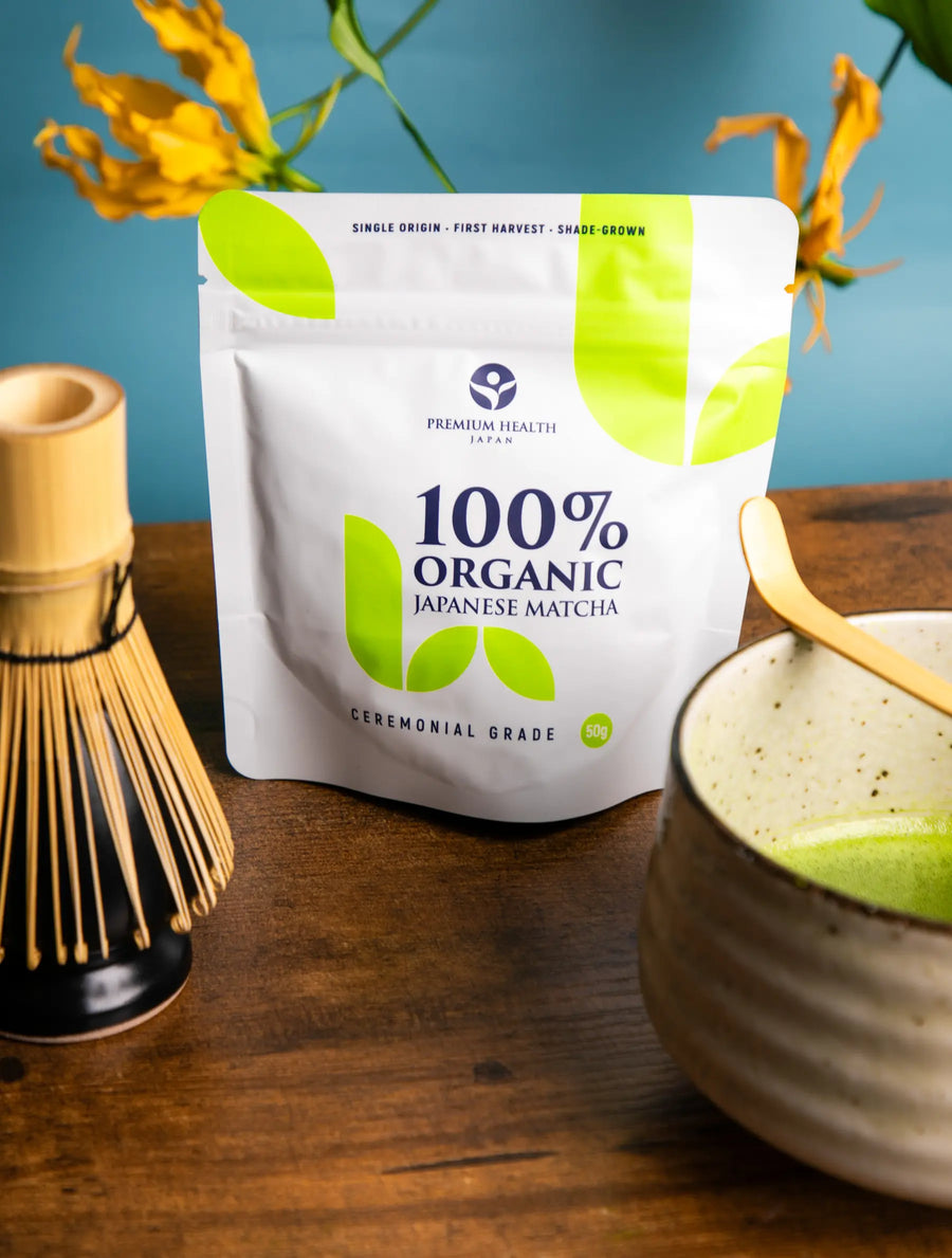 Organic Japanese matcha ceremonial grade 50g pouch displayed with a bamboo whisk and matcha bowl on a wooden table