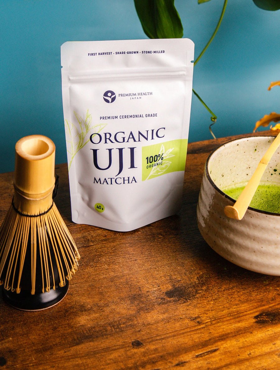 Organic Uji Matcha 40g ceremonial grade pouch with whisk and matcha bowl on wooden table, Premium Health Japan product photo.