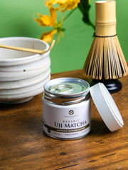 Organic Uji Matcha Saemidori cultivar in a 30g tin with the lid open beside a matcha bowl and bamboo whisk