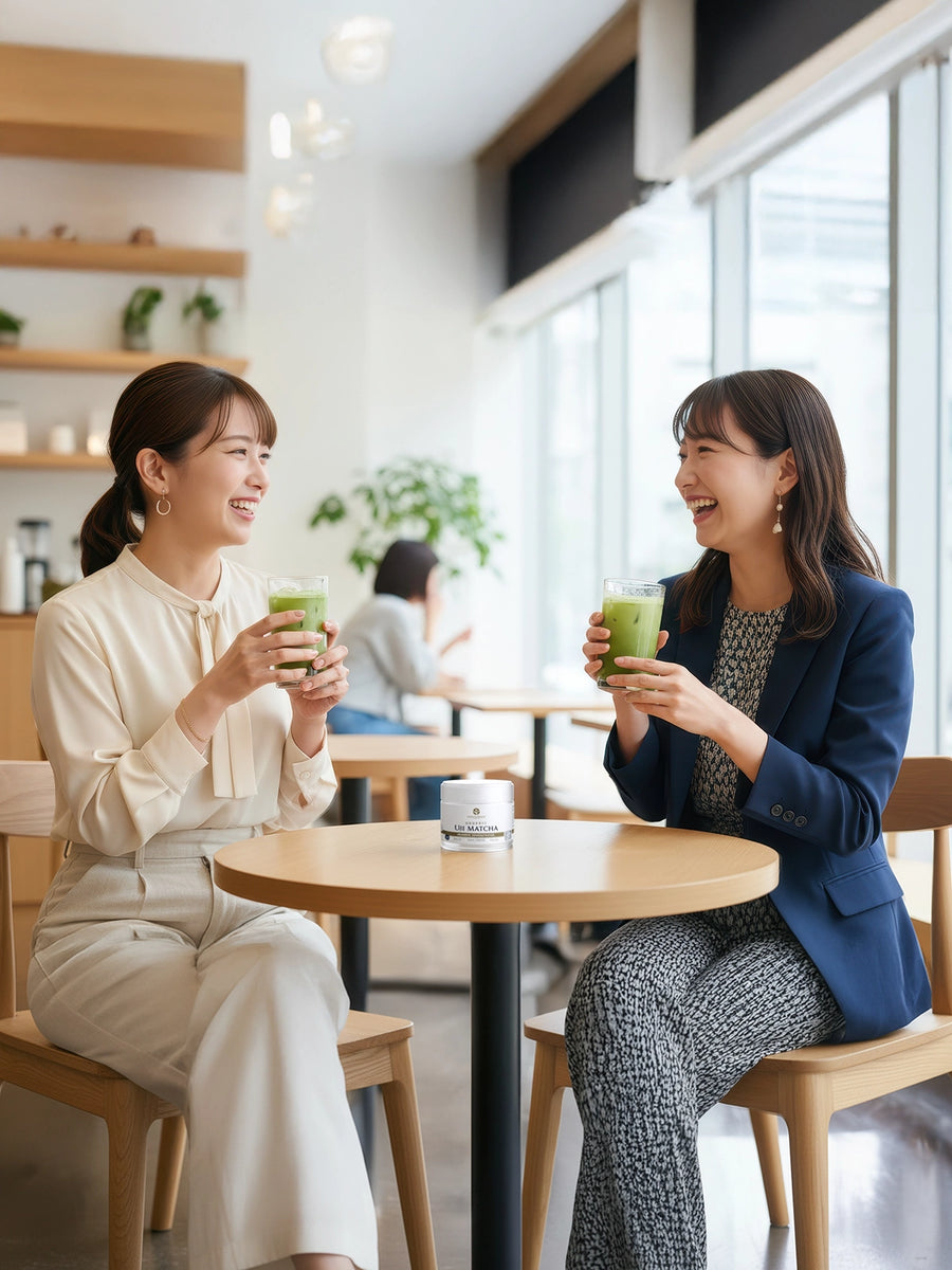 Two people enjoying iced matcha drinks in a café with a tin of Organic Uji Matcha Saemidori on the table.