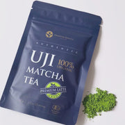 Close-up of a packet of premium latte-grade matcha with a small pile of matcha powder beside it
