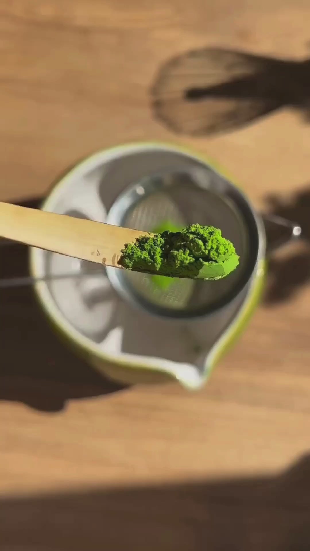 Preparing traditional matcha tea with a bamboo whisk