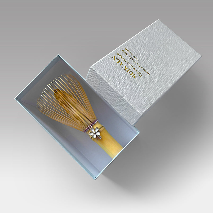 Suikaen pink-thread chasen matcha whisk with sakura charm in gift box, handcrafted in Takayama, Japan.