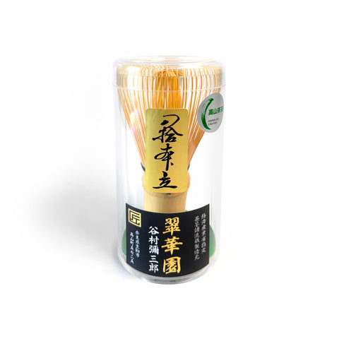 Traditional Japanese matcha whisk handcrafted in Takayama by Suikaen, displayed in clear cylindrical case with gold and black label.