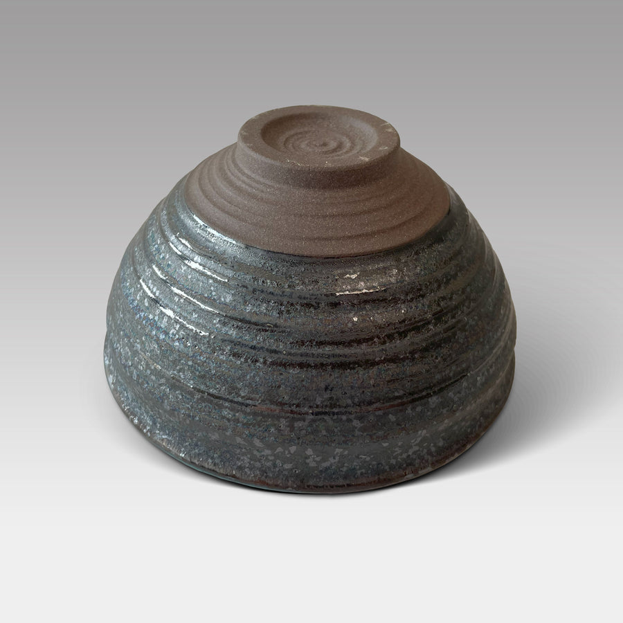 Bottom view of handcrafted Japanese matcha chawan with ridged base and textured teal-glazed stoneware exterior
