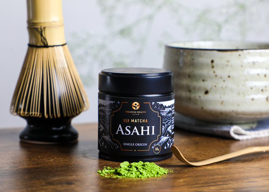 Uji Matcha Asahi 30g single-origin tin with bamboo whisk, chashaku, and matcha powder beside a chawan, reflecting Kyoto’s traditional tea culture.