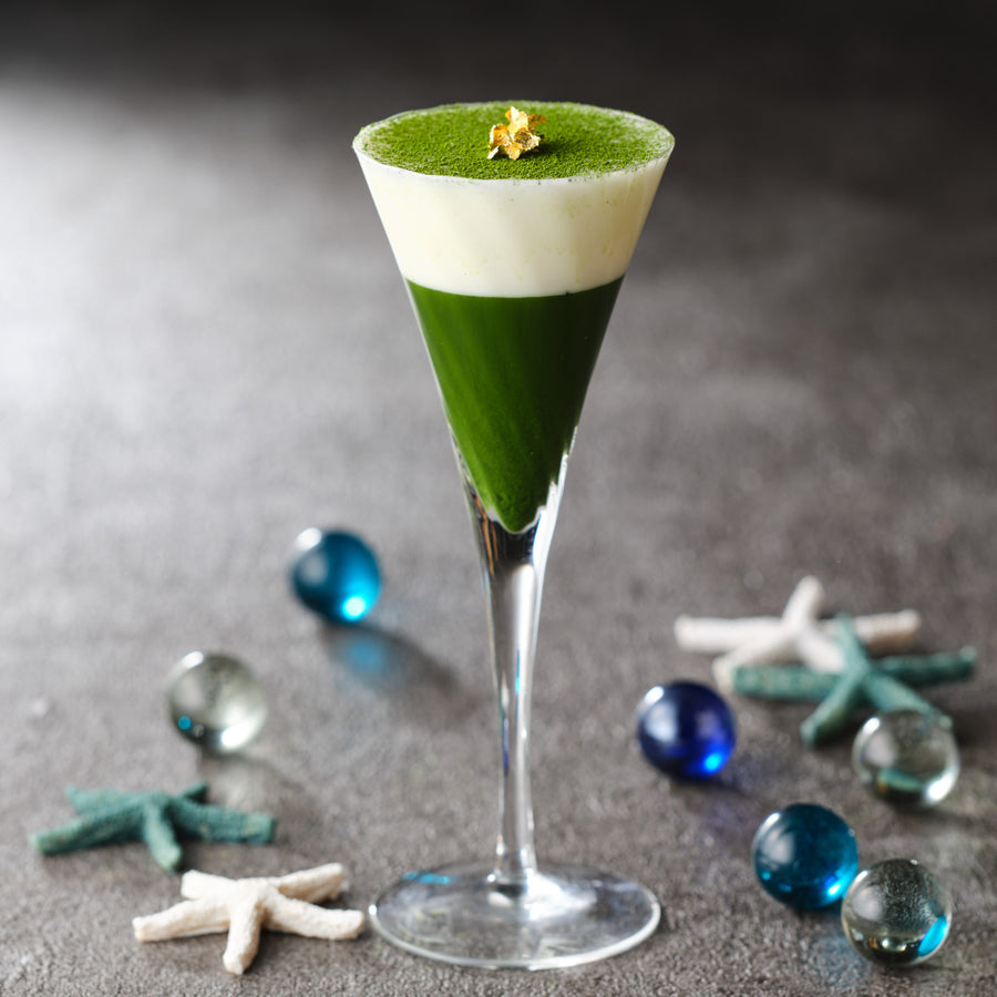 Matcha dessert in a tall glass flute made with Uji Matcha Asahi — green matcha layer, white cream layer, dusted top with gold leaf
