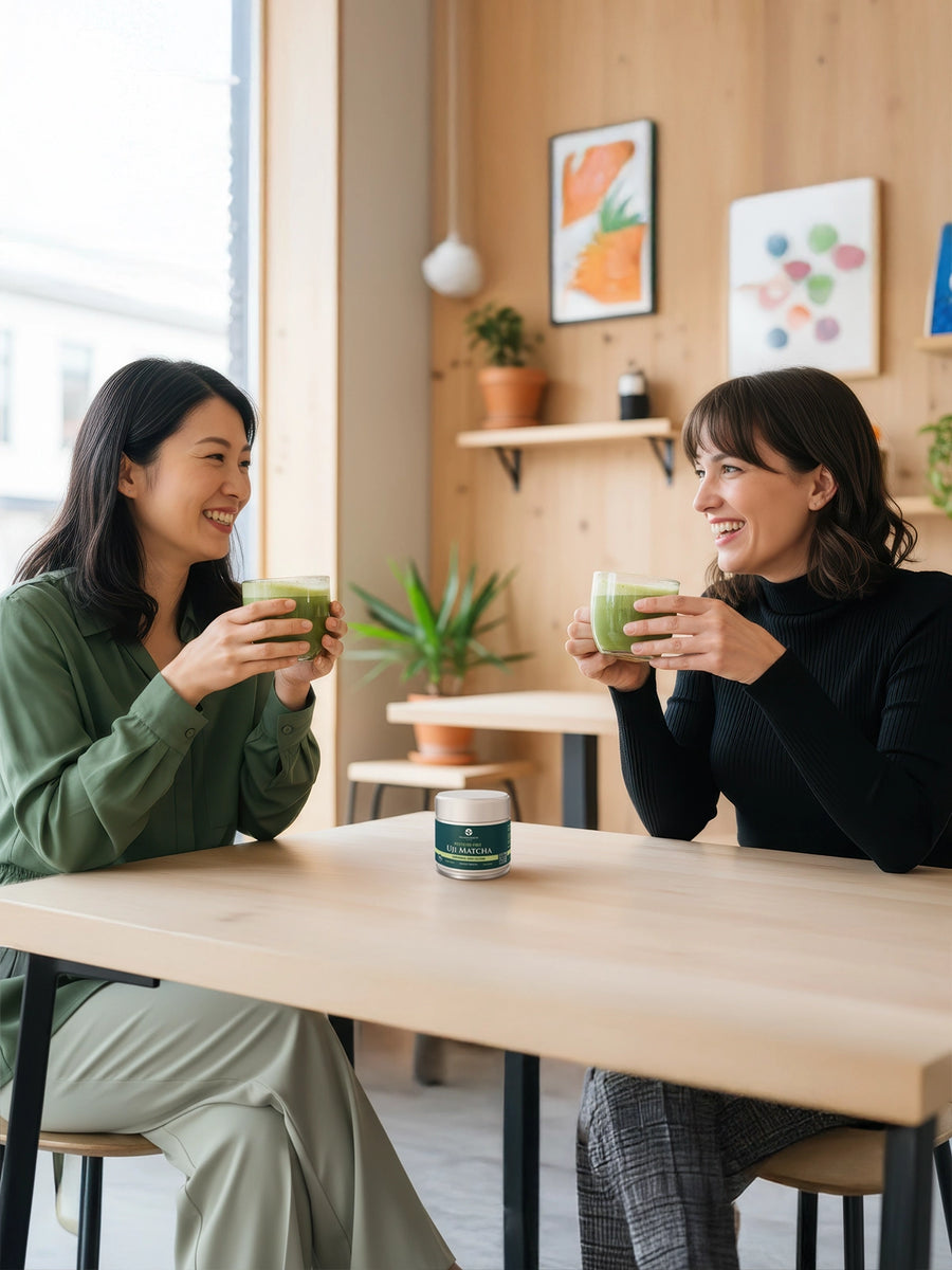 Two people enjoying hot matcha drinks in a café with a tin of Uji Matcha Gokō placed on the table.