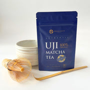 Product image of organic ceremonial matcha next to a matcha bowl, bamboo whisk, and a chashaku